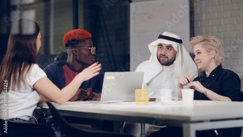 A group of young businessmen of different races are actively discussing business details in a negotiation room. Brainstorming.