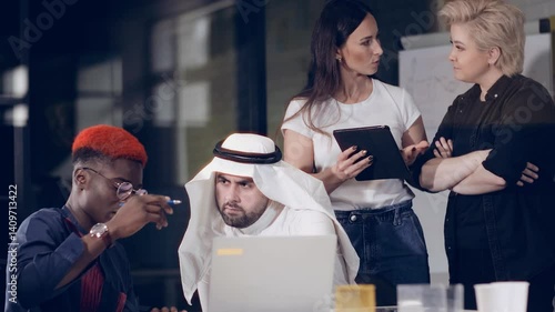 A group of young businessmen of different races actively discuss business details in a negotiation room.