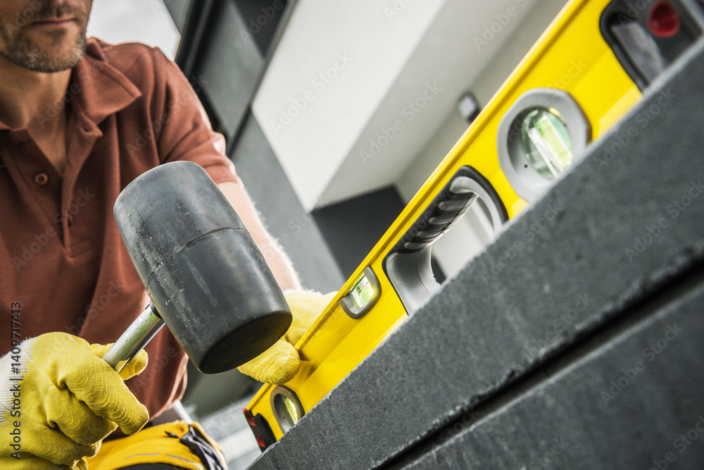 Worker Using Level Tool to Align Construction Materials Outdoors