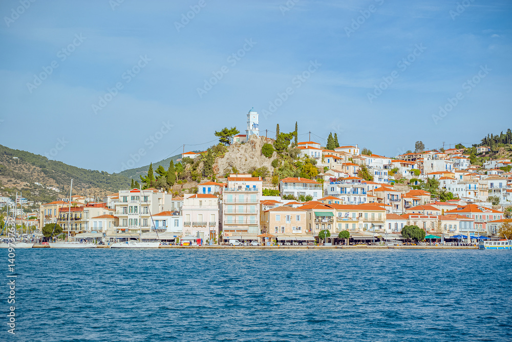 Obraz premium Poros Island, Saronic, Greece: Greek island townscape with blue water and sky
