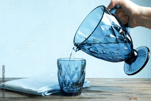 Woman's hand pouring water from jug