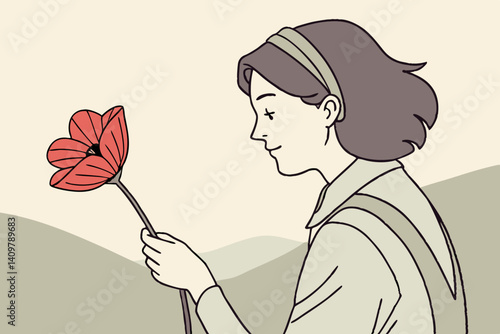 Young woman admiring a red flower against a soft landscape  