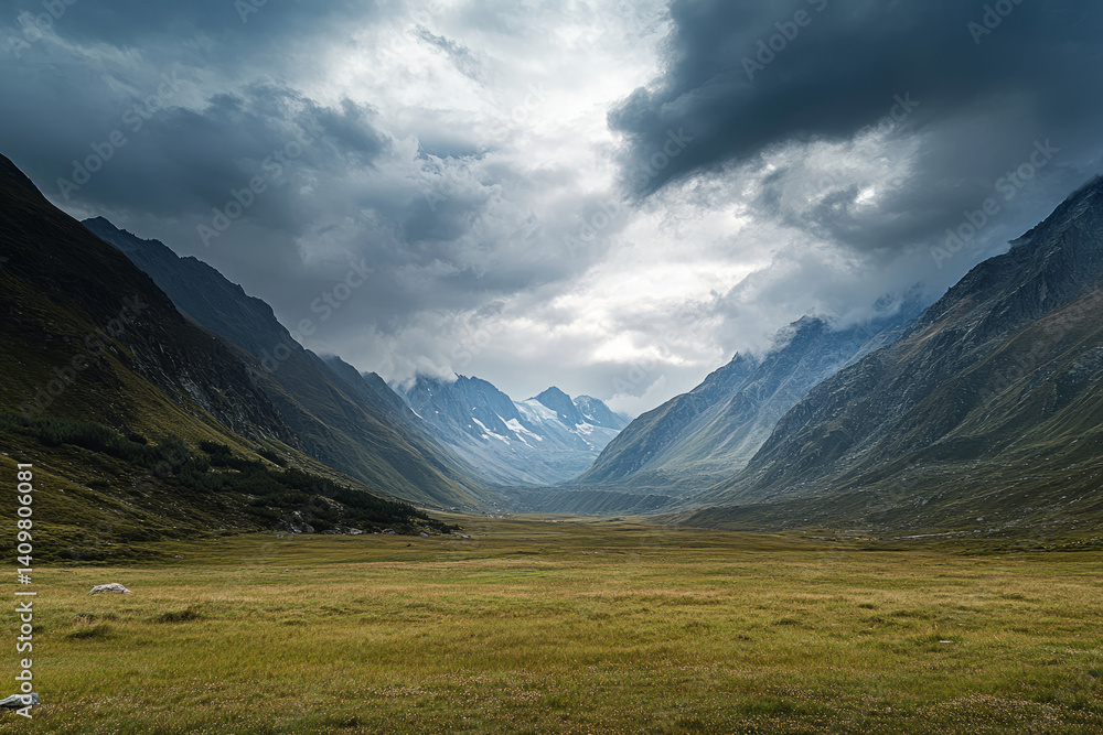 Fototapeta premium Dramatic mountain landscape under stormy sky with layered hills and sunlit valleys in distance