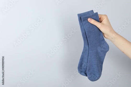 Obraz na płótnie Woman with pair of socks on light grey background, closeup. Space for text w salonie