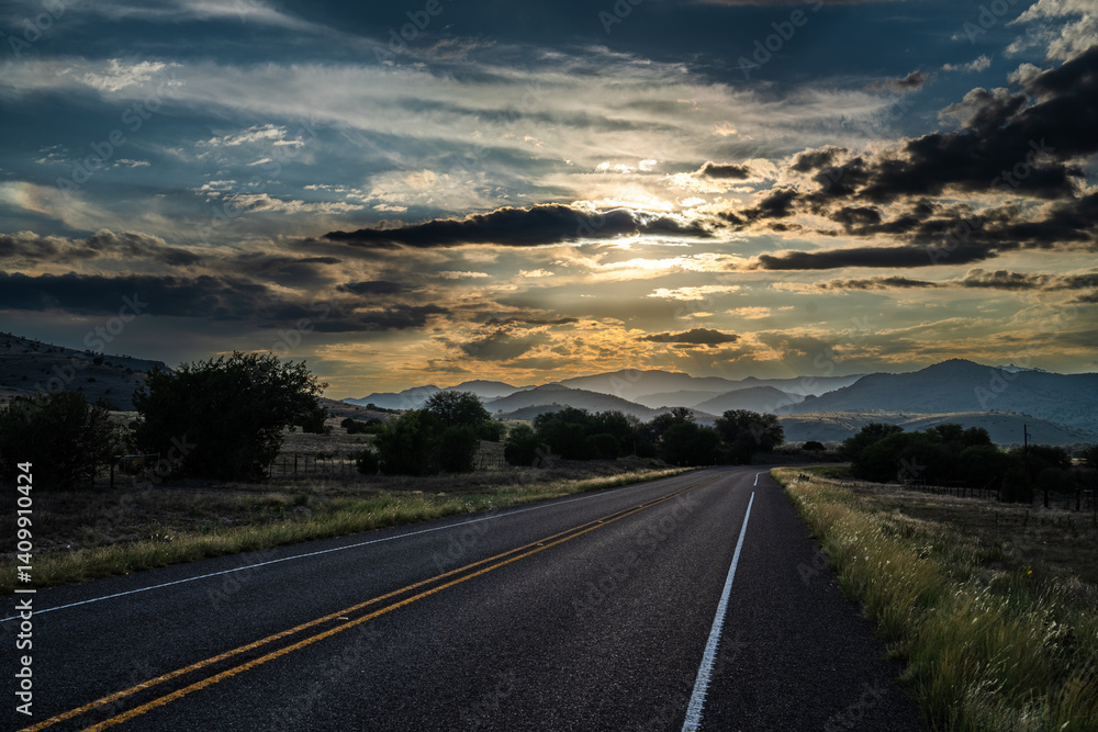 Fototapeta premium Dramatic sky over mountainous range at the end of a 2 lane highway as the sun setting, Mt Livermore, Highway 118, Davis Mountain, McDonald Observatory, Texas