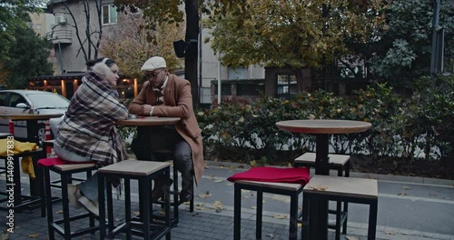 Wallpaper Mural A couple enjoys a quiet moment together at an outdoor cafe in the city during autumn, wrapped in cozy blankets. Torontodigital.ca