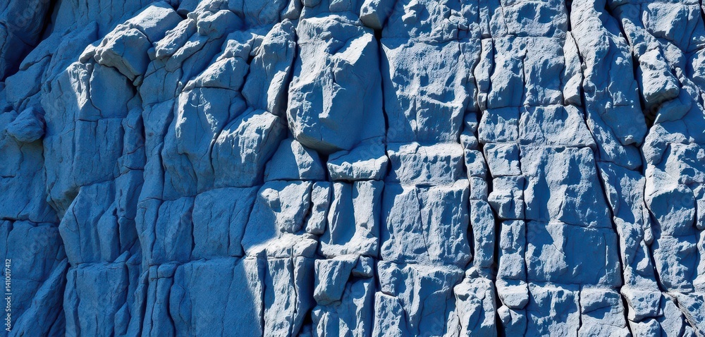 Steep cliff face of textured blue rocks, natural light, earth, wall, mountain