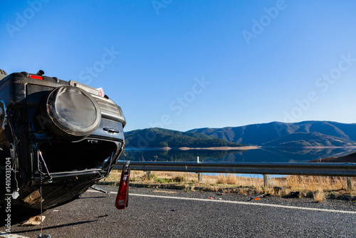 Crashed car flipped onto roof on rural road with copy space