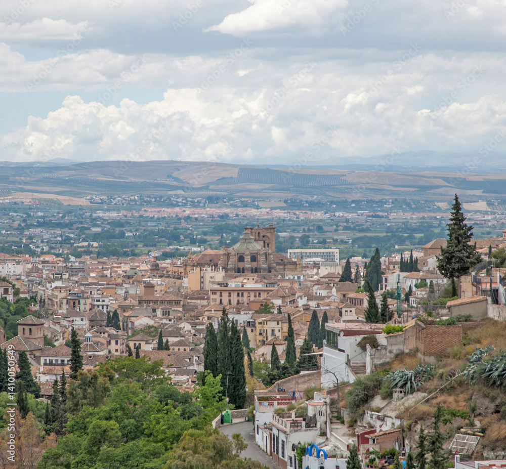 Granada cityscape with cathedral, hills, and cloudy sky, Spain Granada cityscape with cathedral, hills, and cloudy sky, Spain