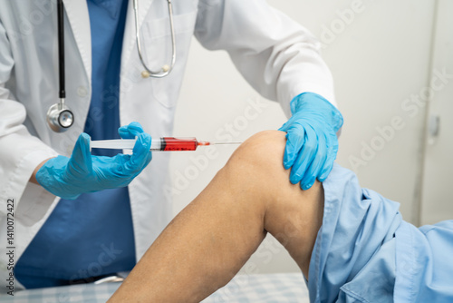 Asian doctor inject Hyaluronic acid platelet rich plasma into knee of senior woman.