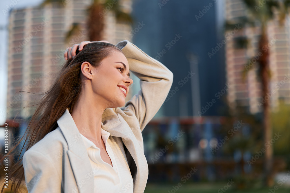 Fototapeta premium Confident businesswoman smiling in a modern urban setting, dressed in stylish office attire, showcasing professionalism and elegance, with a blurred city backdrop.
