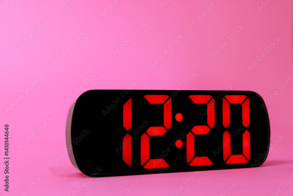 Digital alarm clock showing 12:20 o'clock on pink background, closeup Digital alarm clock showing 12:20 o'clock on pink background, closeup
