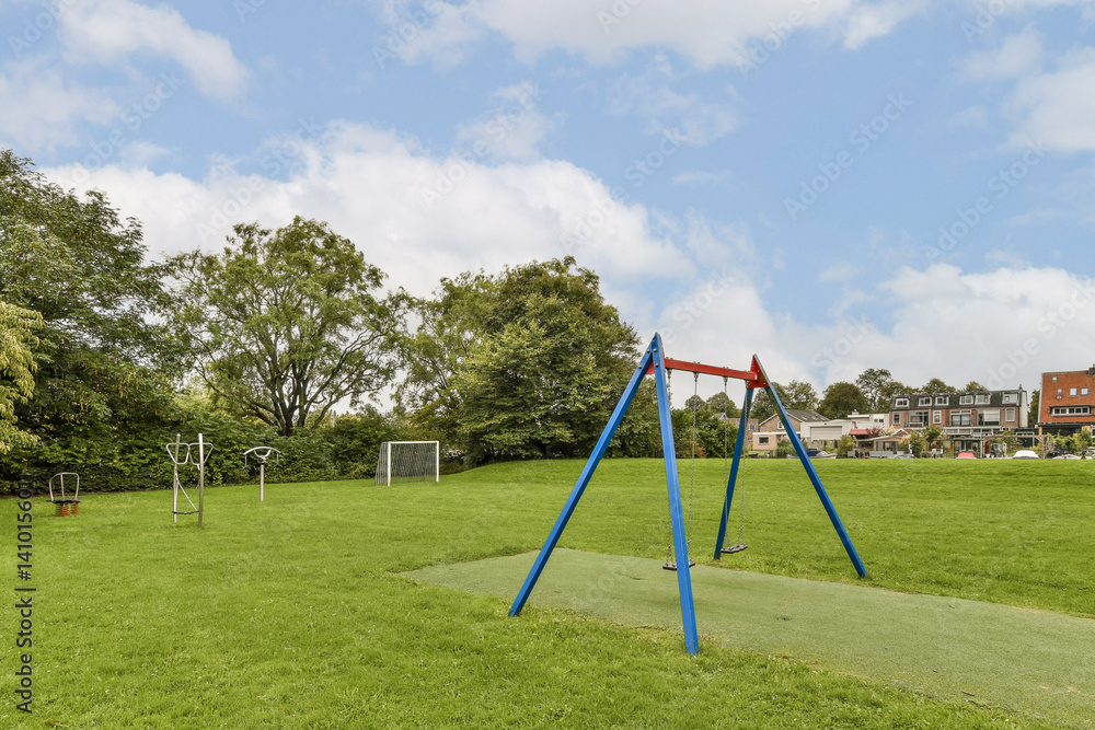 A lively playground featuring colorful swings, lush green grass, and trees creating an inviting environment for play and relaxation. A lively playground featuring colorful swings, lush green grass, and trees creating an inviting environment for play and relaxation.