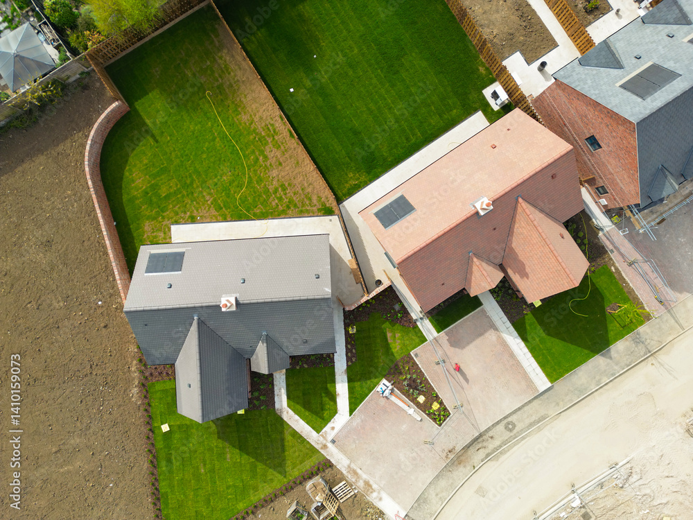 Drone top down view of new detached bungalows seen in a rural development in Britain. New lawns have recently been laid.