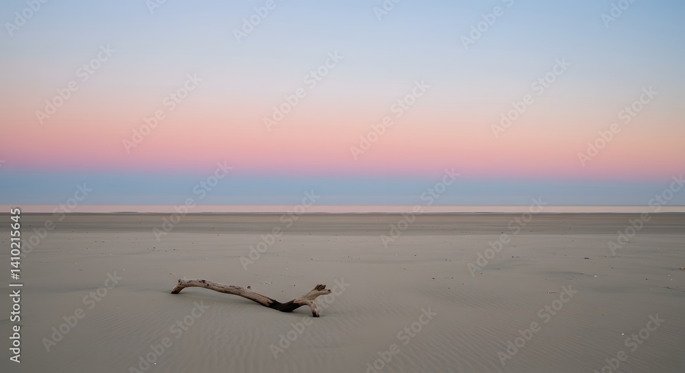 Naklejka premium Peaceful Sunset Over Wide Sandy Beach with Driftwood