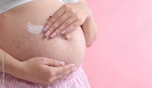 Wallpaper Mural Pregnant woman with cream on belly against pink background, closeup. Space for text Torontodigital.ca