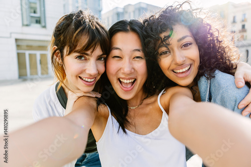 Wallpaper Mural Three multiracial young women having fun on city street. Millennial group of female friends enjoying summer vacation taking selfie portrait outdoors. Friendship and youth concept. Torontodigital.ca