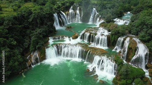Ban Gioc Falls flow through the green mountains in Asia, north of Vietnam, in Cao Bang, towards Lang Son, in summer, on a sunny day. 