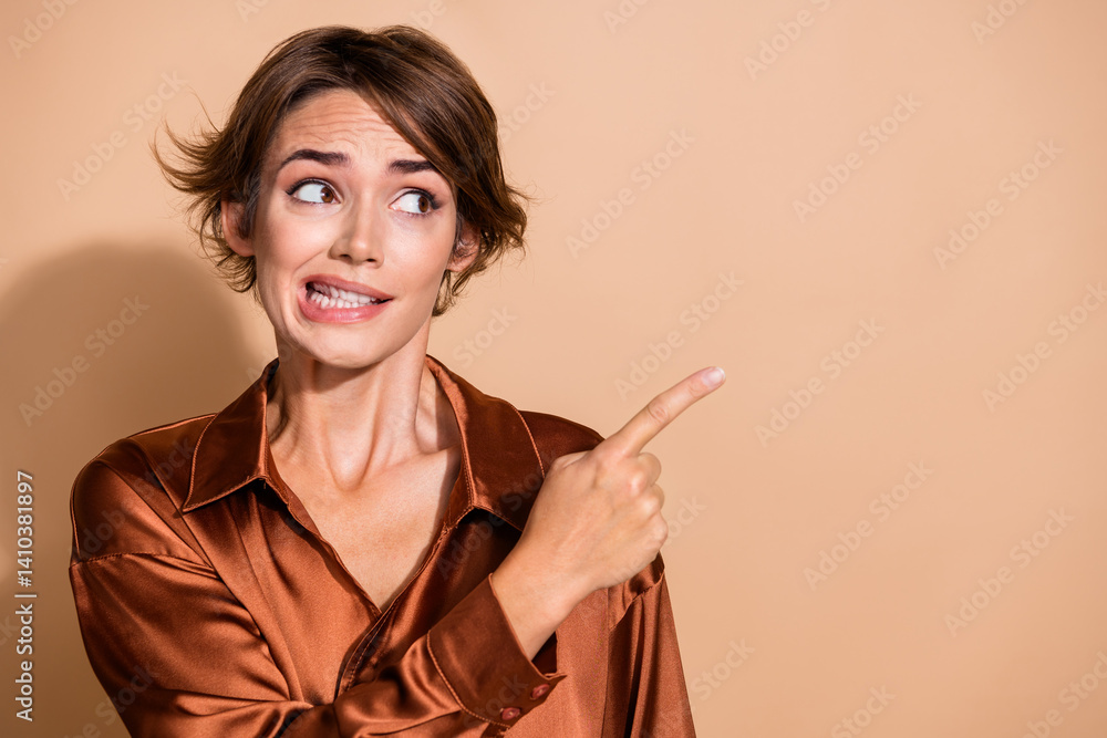 Photo of doubtful unsure lady dressed silky shirt showing finger empty space isolated beige color background