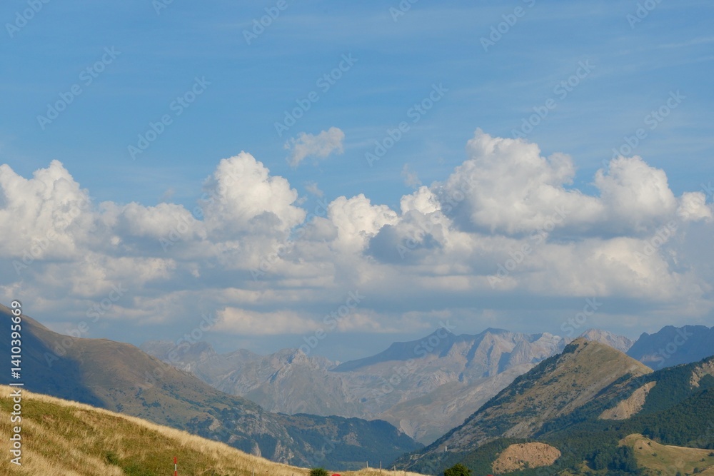 Fototapeta premium Expansive landscape showcases majestic mountains with rolling hills in the foreground