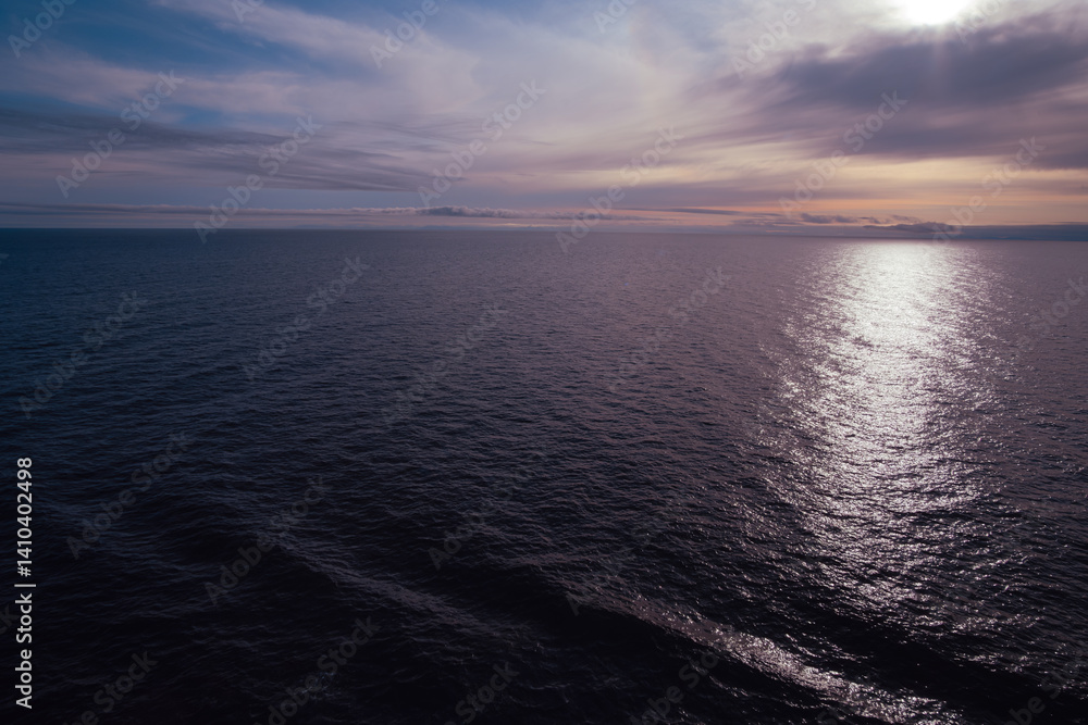 Purple whisps of clouds above calm sea at sunset Purple whisps of clouds above calm sea at sunset