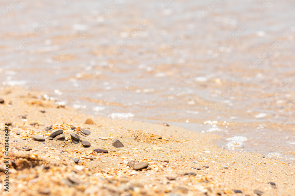 Sea waves with foam near sea or ocean shore. The sandy beach with soft golden sand, shells and rocks. Vacation background. Sea waves with foam near sea or ocean shore. The sandy beach with soft golden sand, shells and rocks. Vacation background.