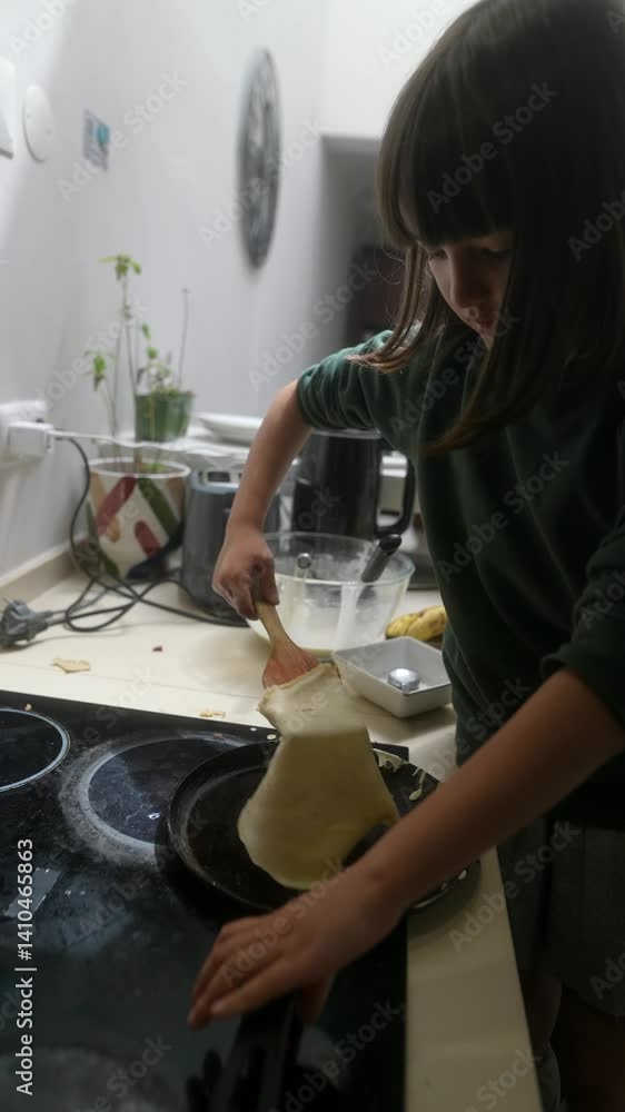 A child joyfully preparing pancakes in the kitchen, fully engaged in the delightful activity A child joyfully preparing pancakes in the kitchen, fully engaged in the delightful activity