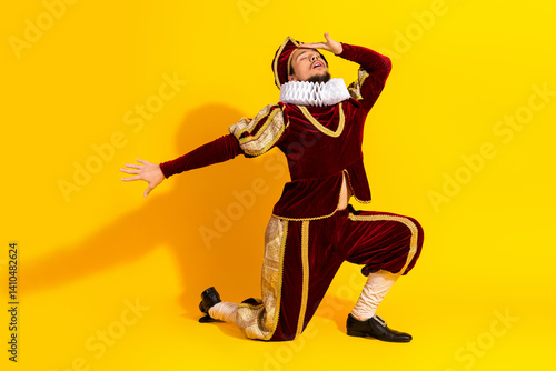 Fotografi Male actor dressed as a nobleman in a red costume posing on yellow