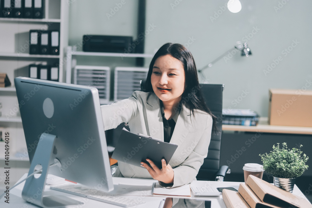 Asian Businesswoman Using laptop computer and working at office with calculator document on desk, doing planning analyzing the financial report, business plan investment, finance analysis concept. Asian Businesswoman Using laptop computer and working at office with calculator document on desk, doing planning analyzing the financial report, business plan investment, finance analysis concept.