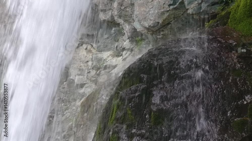 Breathtaking footage of Aber Falls (Rhaeadr Fawr) plunging over rugged cliffs into a rocky valley in Snowdonia National Park, surrounded by Welsh highland scenery.