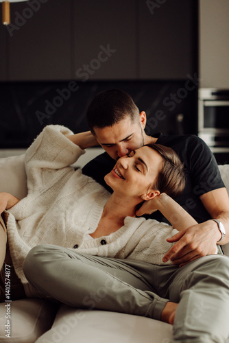 Happy couple relaxing and cuddling on sofa at home