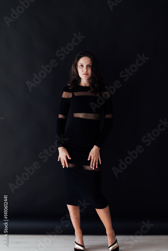 Portrait of a beautiful slender fashionable woman in a black dress