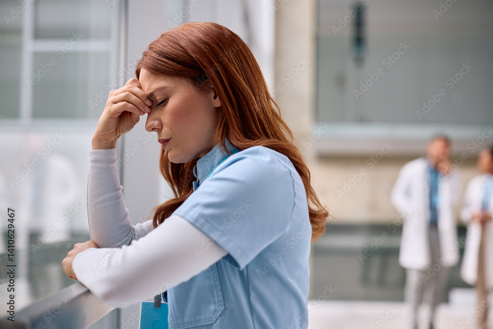 Fototapeta premium Exhausted nurse having a headache while working at the hospital.