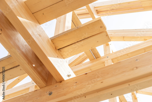 Close-up view of wooden beams and joints in a roof under construction, showcasing structural carpentry and joinery work in residential timber building.