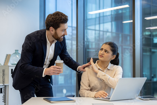 Foto A woman at work rebuffs unwanted attention from a male colleague, conveying discomfort and rejection with body language