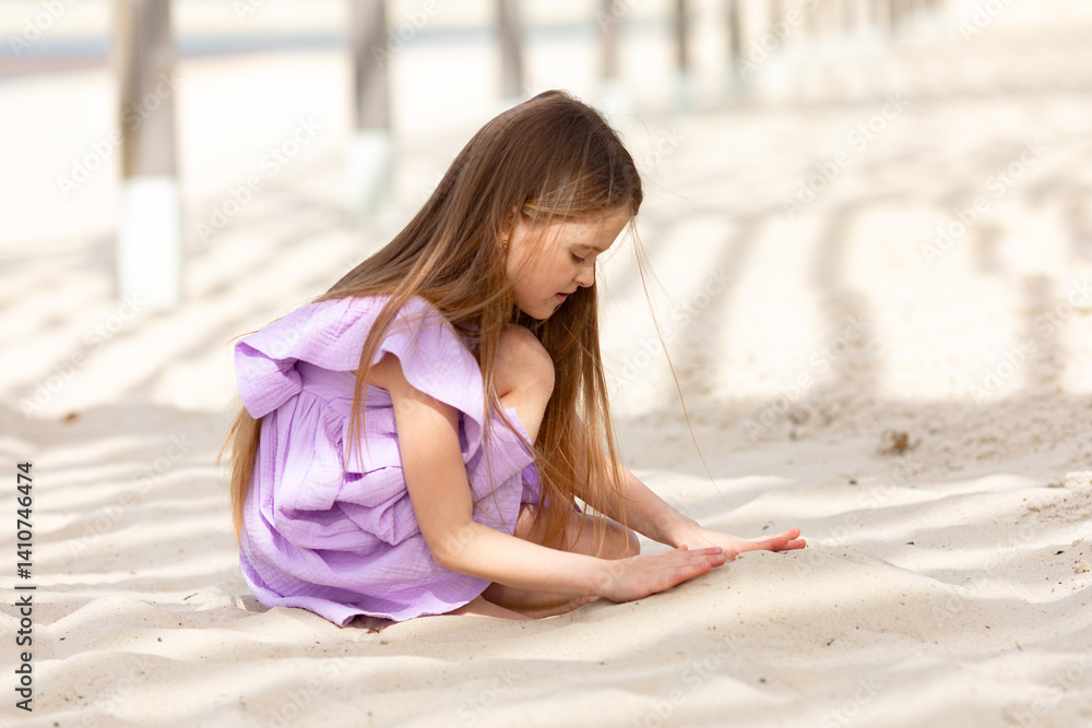 Little cute child girl sitting on tropical beach and playing with sand, smiling on summer vacation. Happy children kid enjoy and has fun. Outdoor activity lifestyle on beach, holiday travel.