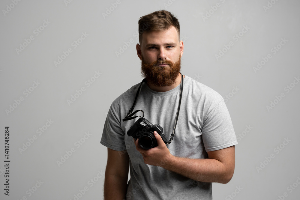 Portrait of bearded professional photographer with photo camera looks straight into the camera. Portrait of bearded professional photographer with photo camera looks straight into the camera.