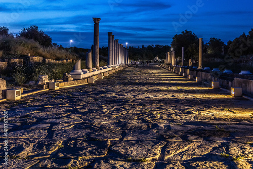 Night view of paved road with columns, both intact and in ruins, from the Roman era in the ancient city of Side. Dramatic twilight sky . Side, Turkey, Mediterranean.