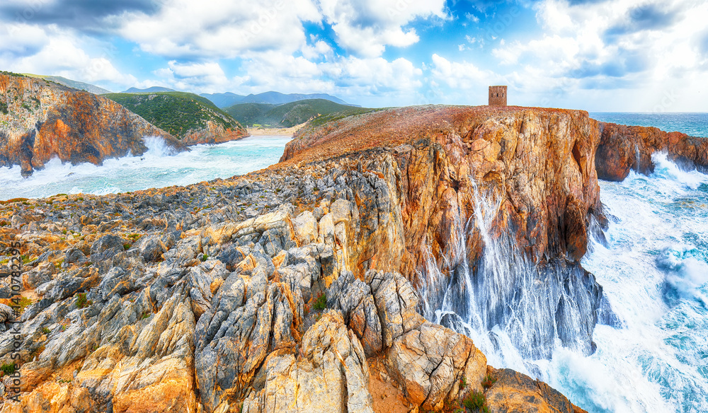 Attractive view of cliffs in valley Cala Domestica with old tower and storm on the sea