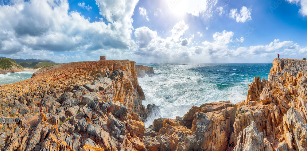 Unbelivable view of cliffs in valley Cala Domestica with old tower and storm on the sea.