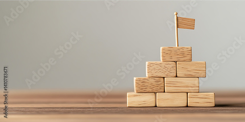 Wooden block tower with flag represents goals and success, achieved step by step. Strategy and planning are key for accomplishment.