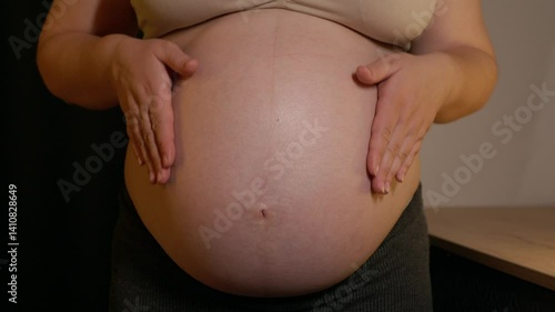 Wallpaper Mural Pregnant woman stroke big belly in anticipation getting ready for the baby. Future mom at 9 months of pregnancy close up. Warm light Torontodigital.ca