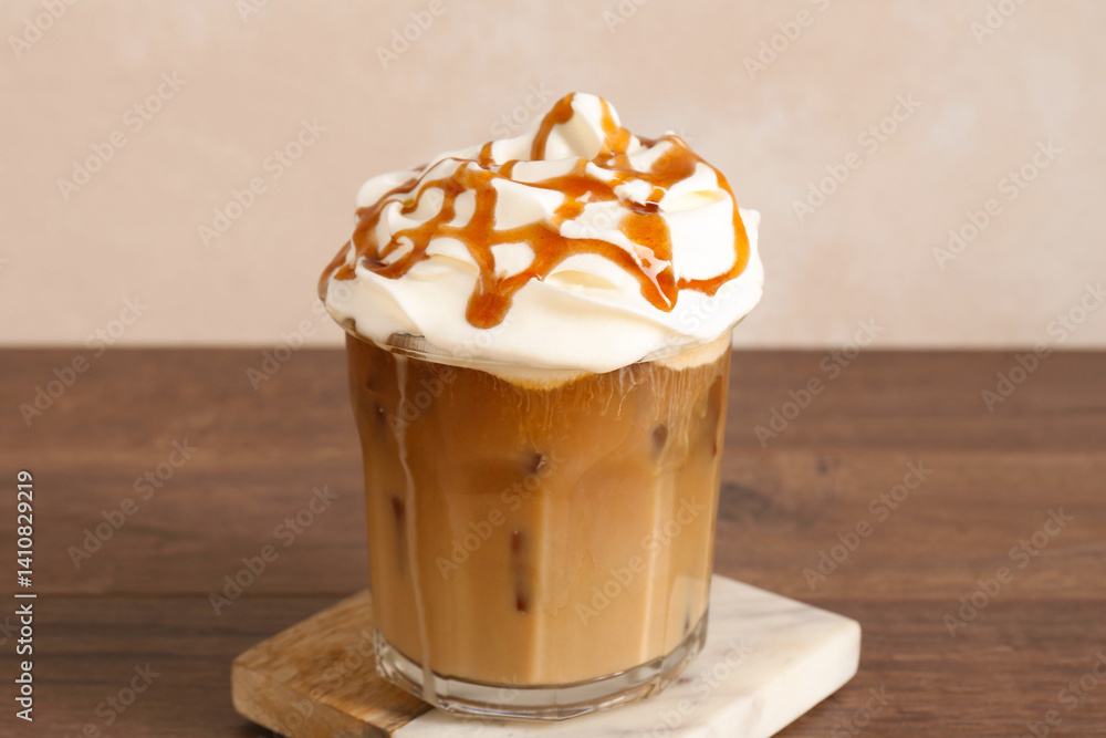 Tasty iced coffee with whipped cream and syrup on wooden table, closeup Tasty iced coffee with whipped cream and syrup on wooden table, closeup
