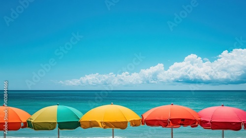 Obraz na płótnie A colorful row of beach umbrellas set up along the shore, with vibrant colors contrasting against the clear blue sky and ocean. w salonie