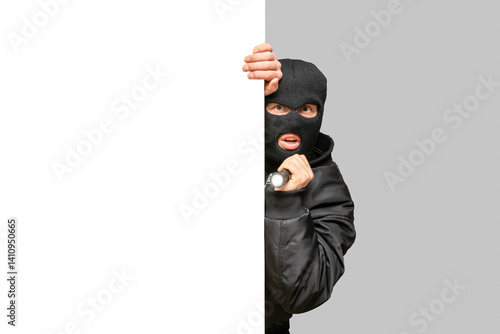 Thief holding flashlight and hiding behind wall