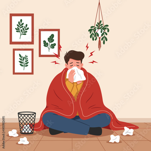 Man with a cold, sitting wrapped in a blanket, blowing his nose, surrounded by tissues.