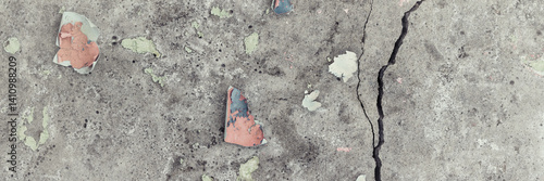 Peeling paint on the wall. Panorama of a concrete wall with old cracked flaking paint. Weathered rough painted surface with patterns of cracks and peeling. Wide panoramic grunge texture for background