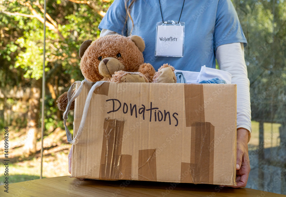 Volunteer Receiving a Donation Box with Toys and Children’s Clothes