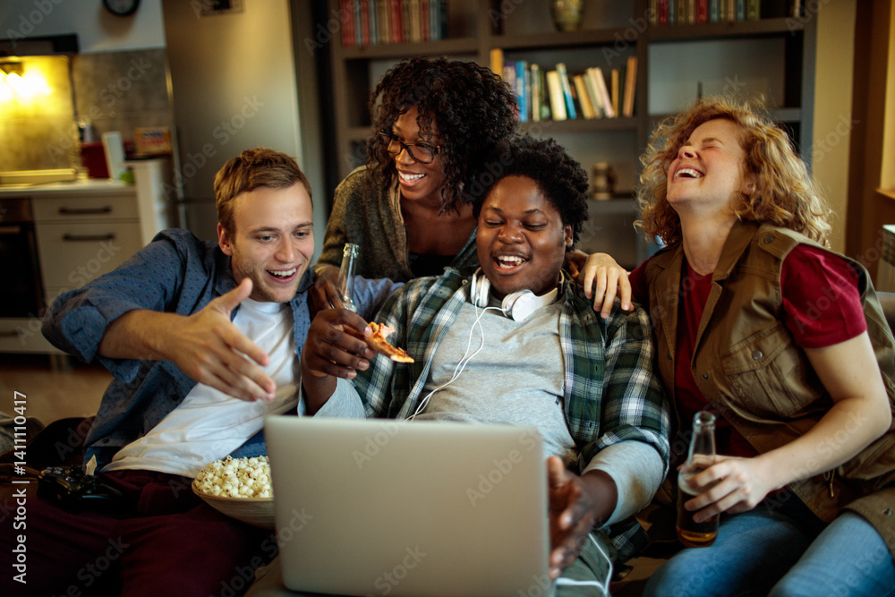 Obraz premium Young and diverse group of friends watching a movie on laptop in the living room on the couch