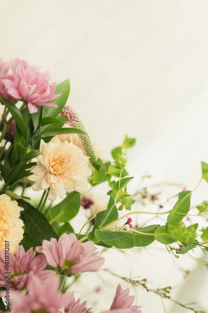 Fototapeta premium Modern soft peach and pink spring blooms with trailing greenery with copy space